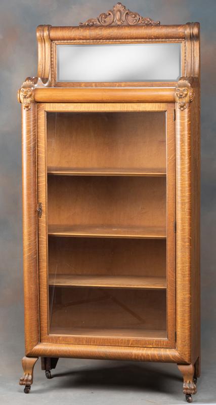 Antique single door, quarter sawn oak Bookcase, circa: Antique single door, quarter sawn oak Bookcase, circa 1900-1910, with claw foot base and lion heads supporting fancy beveled mirror crest. Nice finish and condition, measures 34 1/2" wide x 14 1/2" de