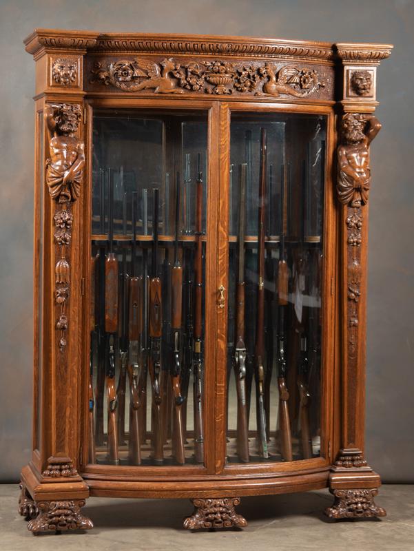 A most impressive antique, full figural carved, quarter: A most impressive antique, full figural carved, quarter sawn oak, double door curved glass Gun Case, circa 1900, attributed to either R.J. Horner or George Flint, early New York cabinet makers. Case h