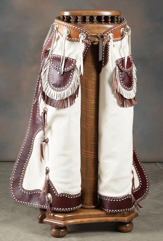 Pair of custom, two-tone, fringed leather Chaps with: Pair of custom, two-tone, fringed leather Chaps with silver spotted border and outside fringed pockets, made by Texas Leathersmith Betty Foster, copy of pattern #300 from catalog #22 on page 86 of the
