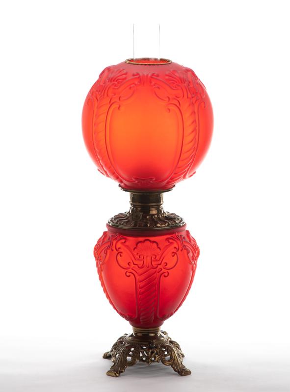 Antique red Gone With the Wind Lamp with embossed base: Antique red Gone With the Wind Lamp with embossed base and matching 10" diameter ball shade. Manufactured in the late 1800s has been converted to electricity. Lamp has a lighted base and measures 25"