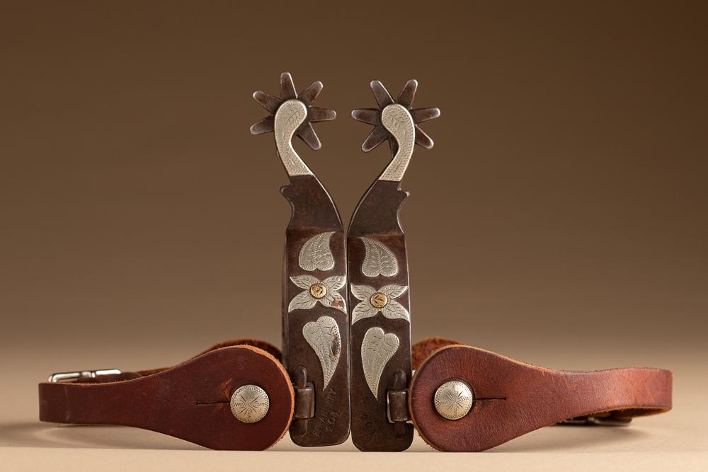 Pair of double mounted Spurs by noted Borger, Texas Bit and Spur Maker Tommy Sprayberry, #201. Spurs: Pair of double mounted Spurs by noted Borger, Texas Bit and Spur Maker Tommy Sprayberry, #201. Spurs are mounted with silver longhorn on one side and floral and leaf on opposite heel bands and are mou