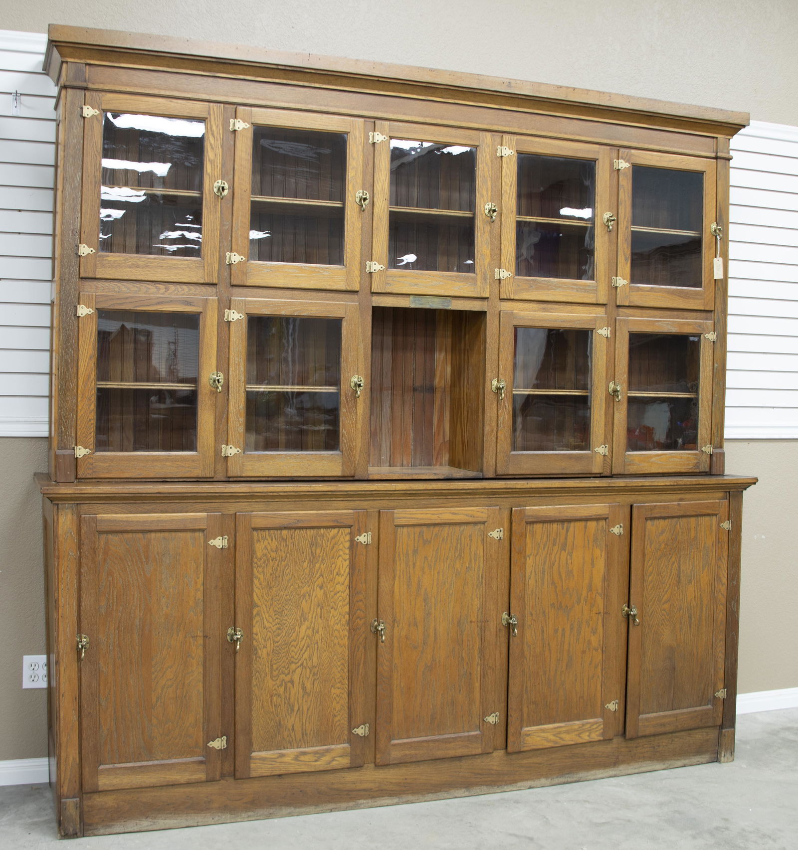 Antique oak two piece, country store Wall Case, circa 1900-1910. Case has original bronze label that: Antique oak two piece, country store Wall Case, circa 1900-1910. Case has original bronze label that states, "New Service Display Counters, Cases, Racks, Etc. SN 55835, Fort Worth, TX." The upper port