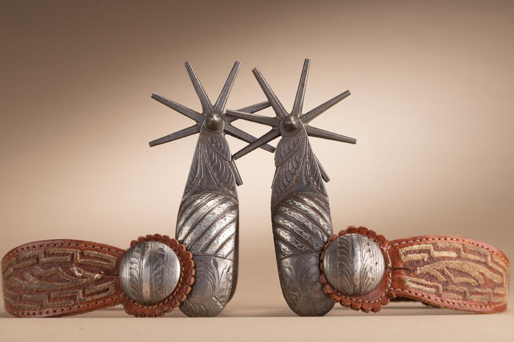 Fine pair of Mexican, heavily engraved iron Spurs with engraved silver overlay on heel bands, 3": Fine pair of Mexican, heavily engraved iron Spurs with engraved silver overlay on heel bands, 3" multi-point rowels, large swing buttons with silver inlay. Fitted with a fancy pair of cactus weave 2-p