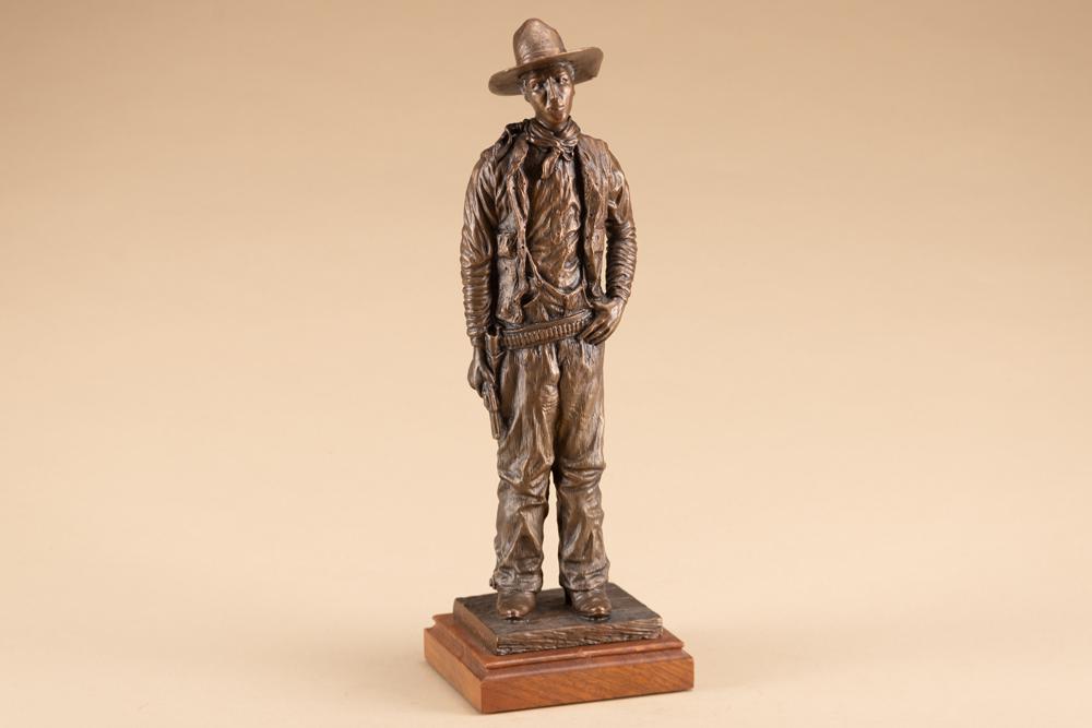Bronze Sculpture by noted artist Jerold Smiley, #6/100, Cowboy with drawn Revolver, measures 15": Bronze Sculpture by noted artist Jerold Smiley, #6/100, Cowboy with drawn Revolver, measures 15" tall overall on a 4 1/2" x 5" wooden base. Noted artist Jerold Smiley makes his home at the foot of the