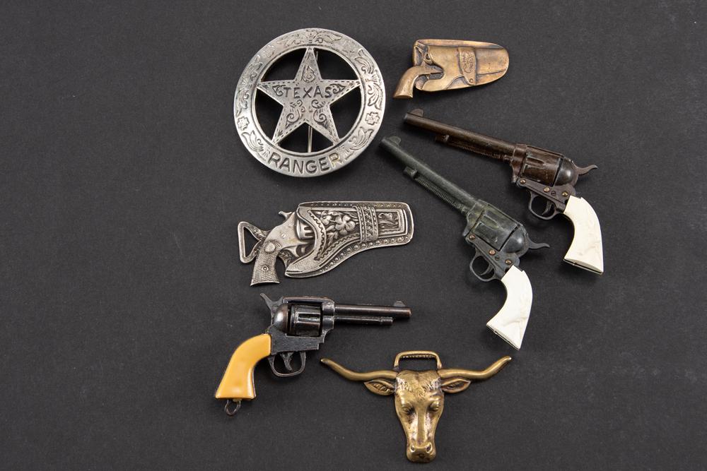 This lot will consist of a collection of 7 items to include: (1) Two miniature long barrel Colt: This lot will consist of a collection of 7 items to include: (1) Two miniature long barrel Colt single action revolvers; (2) One small miniature revolver; (3) Steer head and two pistol watch fobs, one