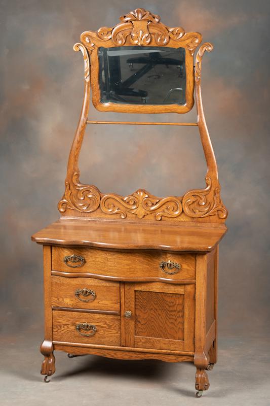 Fancy antique oak Hotel Wash Stand, Sears & Roebuck Model with floral carved high mirrored back and: Fancy antique oak Hotel Wash Stand, Sears & Roebuck Model with floral carved high mirrored back and towel bar, 34" W x 70" T x 17 1/2" D, on fancy claw foot base. Very fine condition and finish.