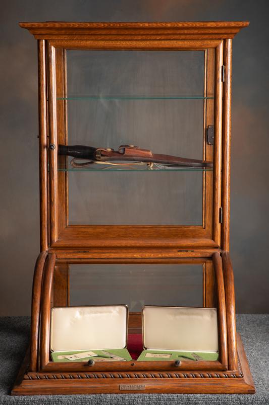 Very desirable oak case curved glass counter top model Showcase with factory bronze label "J.W.: Very desirable oak case curved glass counter top model Showcase with factory bronze label "J.W. Winchester". Case measures 33" T x 22" W x 19 1/2" D with both front and rear entry. Excellent finish an