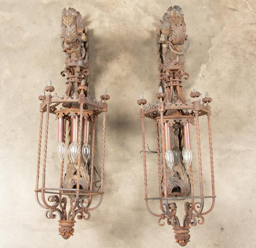 Massive matching pair of vintage cast iron Wall Sconces with metal leaf decoration. Fixture measures: Massive matching pair of vintage cast iron Wall Sconces with metal leaf decoration. Fixture measures approximately 41" L x 10" W and will protrude from the wall 16". In original weathered condition of