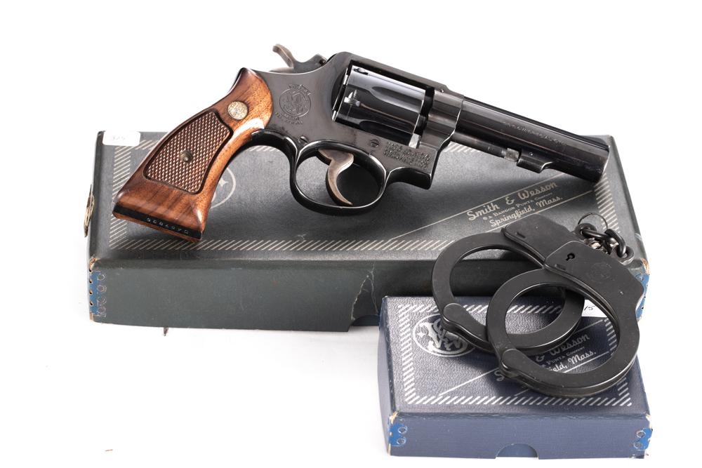Boxed Smith & Wesson Model 10-6 Double Action Revolver, .38 SPL caliber, SN D487836. Excellent blue: Boxed Smith & Wesson Model 10-6 Double Action Revolver, .38 SPL caliber, SN D487836. Excellent blue finish showing light turn line and light thinning at muzzle, 4" heavy barrel, original checkered gri
