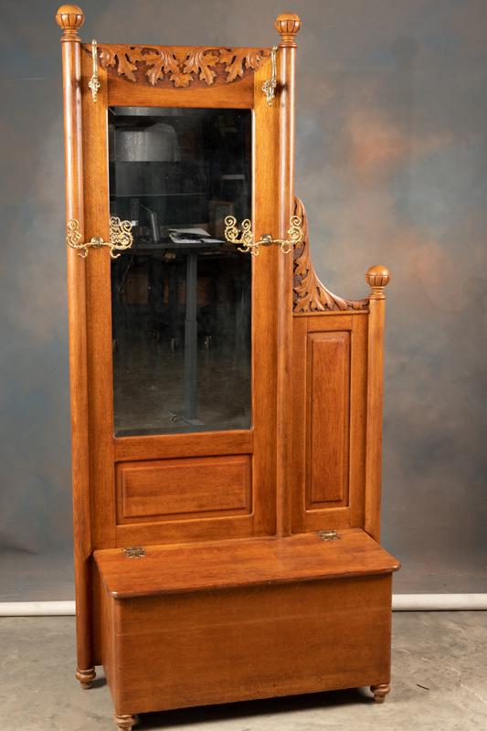 Unusual quarter sawn oak antique lift seat Hall Tree with fancy brass hat hooks and triple finial: Unusual quarter sawn oak antique lift seat Hall Tree with fancy brass hat hooks and triple finial crest with deep carving. Circa 1900. Overall nice finish and condition. Hall tree has original beveled