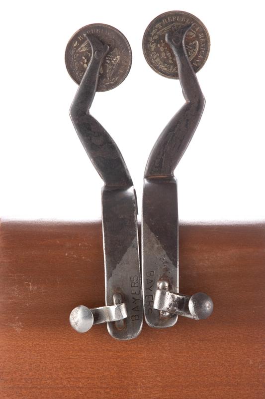Pair of vintage iron gal leg Spurs marked under swing button, "Bayers" with large silver Mexican: Pair of vintage iron gal leg Spurs marked under swing button, "Bayers" with large silver Mexican coin rowels. From the late Carolyn Jackson-Hardy Museum Estate Collection, Floydada, Texas.