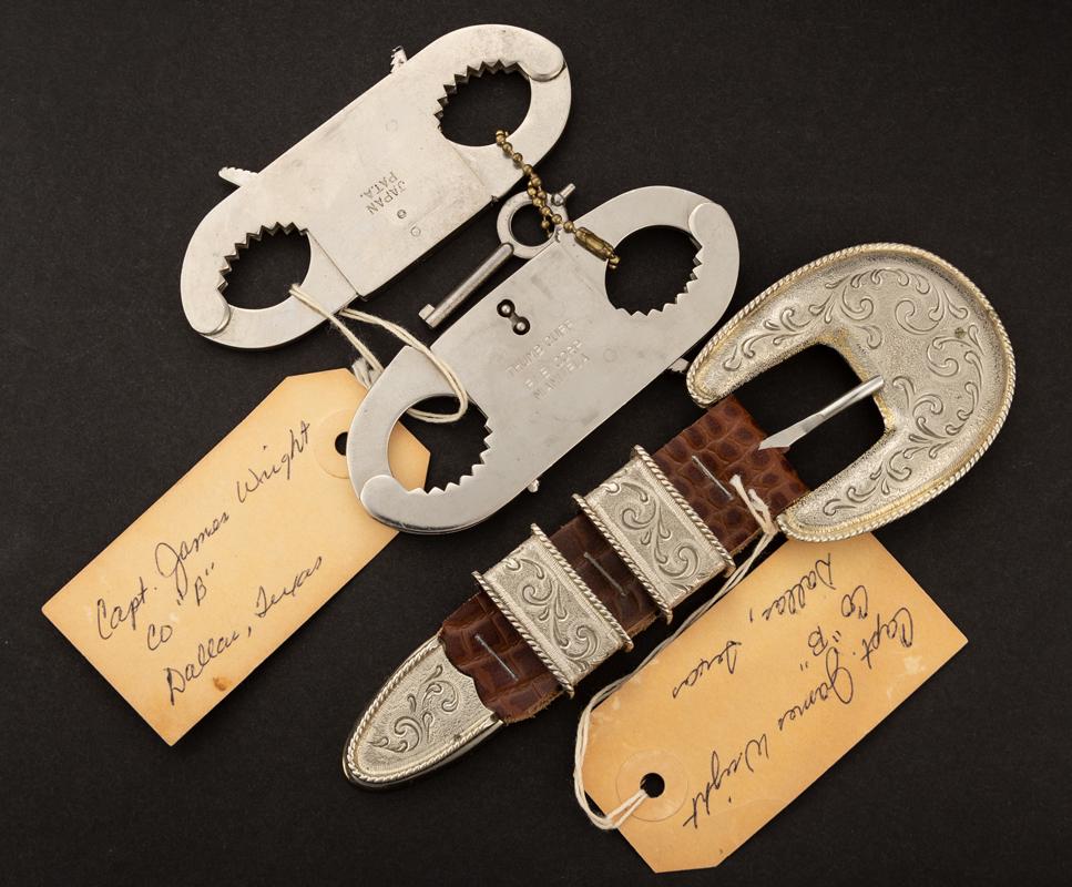 This lot consists of three Items to include: A fancy 4-piece Buckle Set and two sets of Thumb Cuffs: This lot consists of three Items to include: A fancy 4-piece Buckle Set and two sets of Thumb Cuffs with key. All three pieces have old yellow hang tags marked "Captain James Wright, Co., B, Dallas, T