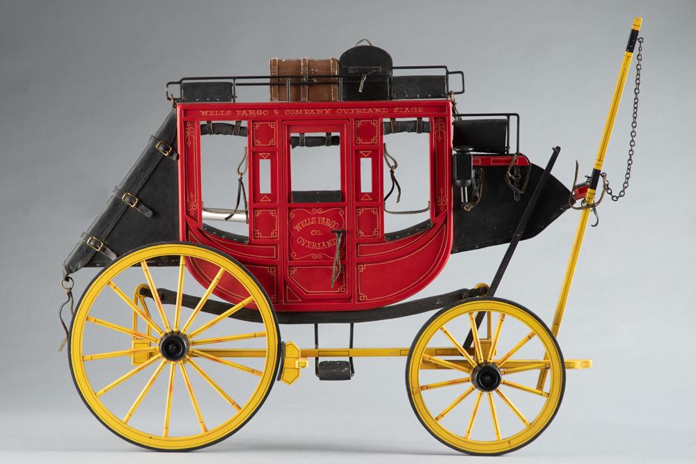 Signed "Dale Ford" wall hanging Wells Fargo Stage Coach, 18" T x 25" L with 8" front wheels and 10": Signed "Dale Ford" wall hanging Wells Fargo Stage Coach, 18" T x 25" L with 8" front wheels and 10" back wheels. A very unique find!