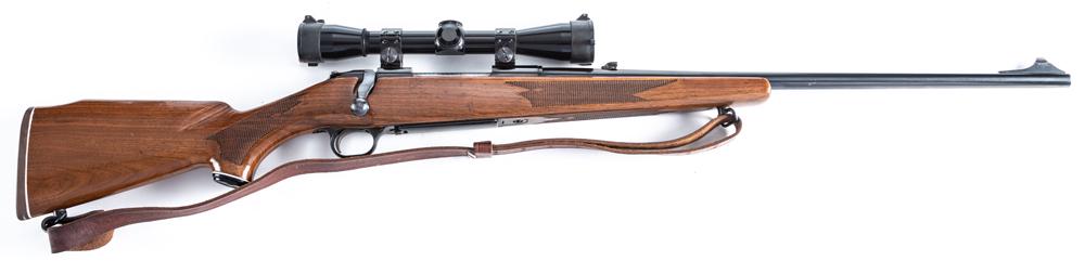 Mossberg Model 810AH Bolt Action Rifle, .30/06 caliber, SN 647619, blue finish, 23" barrel,: Mossberg Model 810AH Bolt Action Rifle, .30/06 caliber, SN 647619, blue finish, 23" barrel, checkered stock with Monte Carlo cheek, showing some light handling marks, with leather carry strap. Mounted