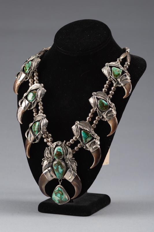 Beautiful turquoise and bear claw Squash Blossom with "Sterling" marked 4" x 2 1/2" Naja, two: Beautiful turquoise and bear claw Squash Blossom with "Sterling" marked 4" x 2 1/2" Naja, two strands of Navajo Pearls, marked "DV". THE LATE DEAN FLOCK ESTATE, WYOMING.