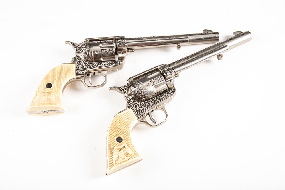 Pair of Movie Prop Guns made in the likeness of a pair of Colt Single Action Revolvers with: Pair of Movie Prop Guns made in the likeness of a pair of Colt Single Action Revolvers with checkered grips. WILL BE SOLD AS ONE LOT. BUDDY KING COLLECTION.