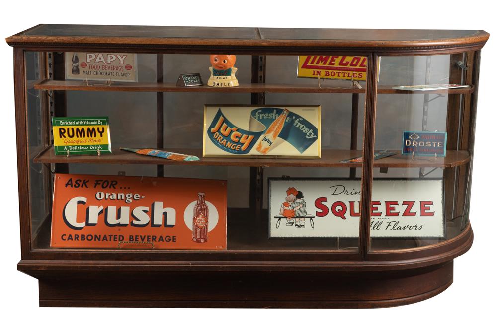 Unique oak curved glass floor model Showcase with double sliding glass doors, circa 1900, with: Unique oak curved glass floor model Showcase with double sliding glass doors, circa 1900, with double adjustable shelves, in original finish, measures 74" L x 42" T x 24" D. Brass label marked "Kirk &
