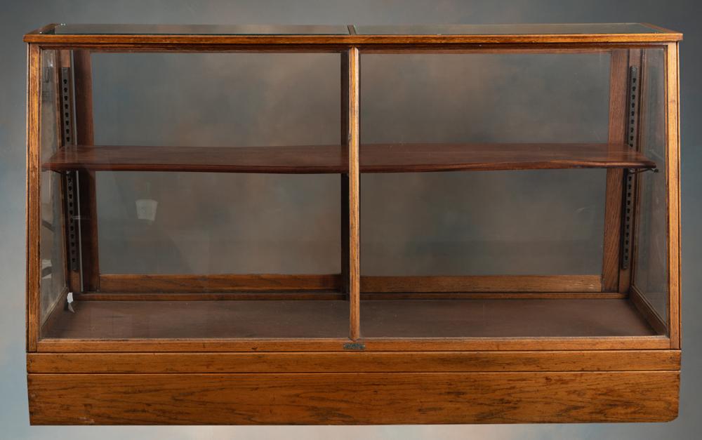 Unique antique oak slant front country store Showcase, circa 1900, label on front reads "National: Unique antique oak slant front country store Showcase, circa 1900, label on front reads "National Button Exhibitor, Manufactured by H. Hoffman, Manning, Iowa". Double sliding glass doors at rear, adju