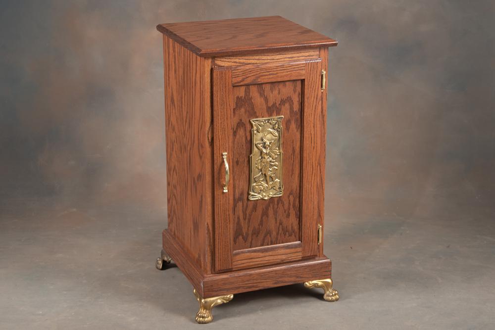 Custom oak single door Cabinet with pull out drink tray, brass medallion on front, sits on brass: Custom oak single door Cabinet with pull out drink tray, brass medallion on front, sits on brass claw feet. Cabinet measures 17 1/2" W x 17" D x 34" T, excellent condition with storage area behind doo