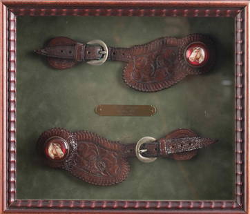 Framed pair of "R.T. Frazier, Pueblo, Colorado" marked two-piece floral Straps with glass horsehead: Framed pair of "R.T. Frazier, Pueblo, Colorado" marked two-piece floral Straps with glass horsehead rosettes. Bronze label inside frame is marked "Circa 1911". Spur Straps appear to be in very good