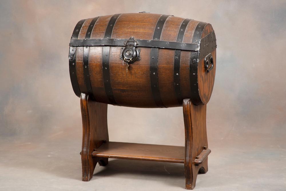 Unique two-piece Whisky Barrel Bar with three pressed glass decanters and four etched glass shot: Unique two-piece Whisky Barrel Bar with three pressed glass decanters and four etched glass shot glasses. Barrel has metal straps and iron handles, with lock & key. Barrel measures 28" T x 23" W x 18"