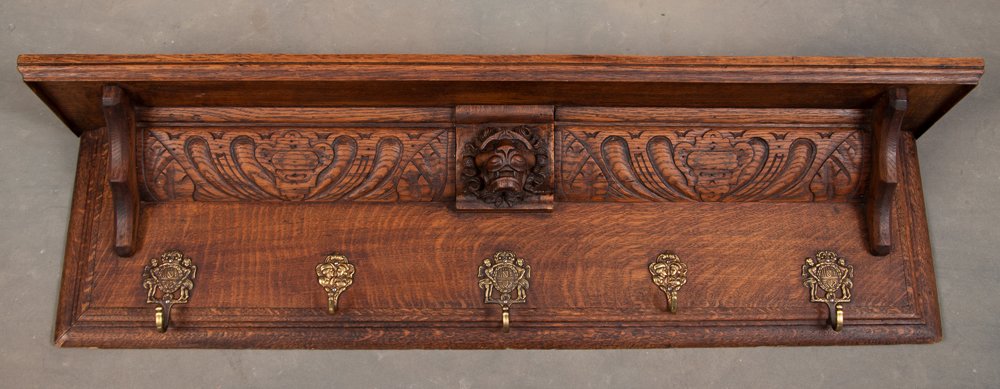 Beautiful quarter sawn oak antique hanging Shelf / Coat Rack with carved lion head in center and: Beautiful quarter sawn oak antique hanging Shelf / Coat Rack with carved lion head in center and five ornate coat hooks, circa 1900, measures 43 1/2" L x 11 3/4" T with a 7 1/2" D shelf.