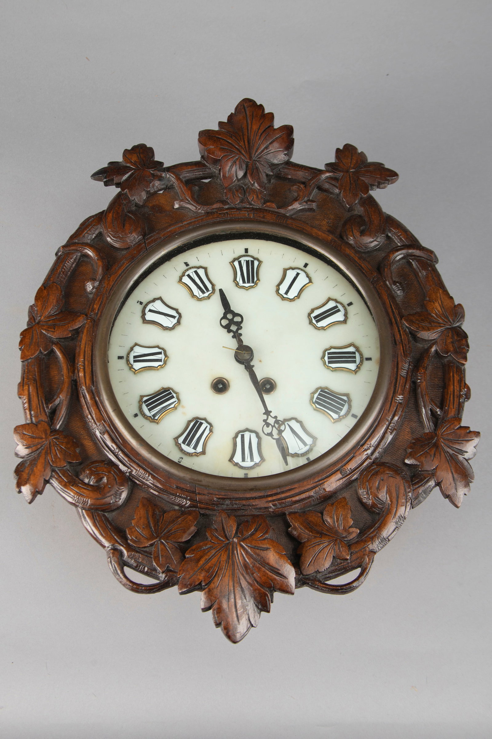 Antique Black Forrest oval shaped Wall Clock with marble dial and porcelain numbers, both time and: Antique Black Forrest oval shaped Wall Clock with marble dial and porcelain numbers, both time and strike in a typical Black Forrest style floral carved case. Clock measures 20 1/4" L x 15 1/2" W. Cas