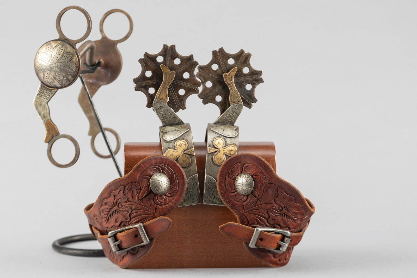 Exceptional three piece Bit and Spur set to include a pair of Spurs and matching Bit, by noted late: Exceptional three piece Bit and Spur set to include a pair of Spurs and matching Bit, by noted late Colorado Bit and Spur Maker Jack Ferguson, (1942-2014). Spurs have hand engraved silver and brass ov