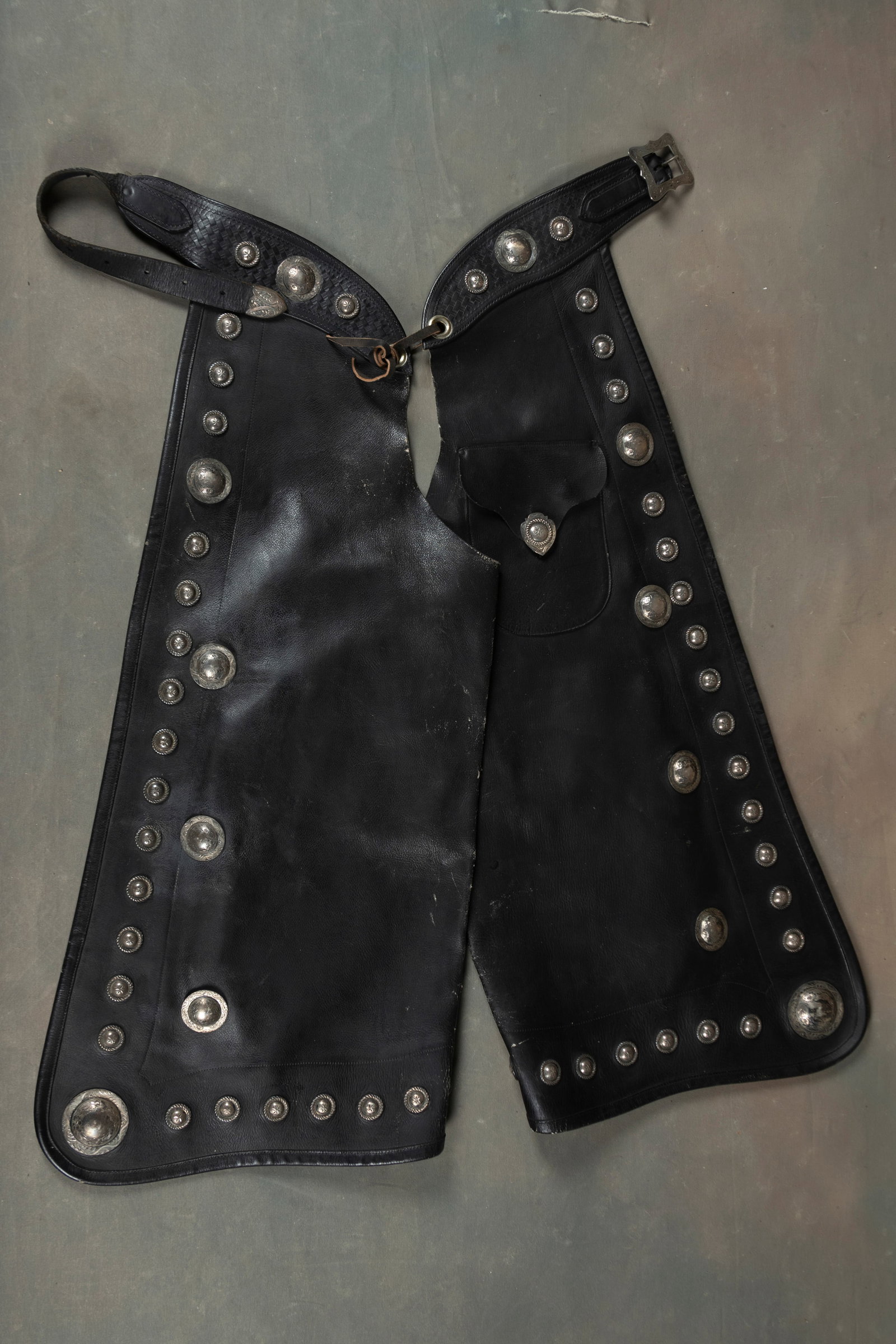 Keyston Bros. silver mounted Bat Wing Show Chaps with over 50 engraved Keyston Bros. silver conchos,: Keyston Bros. silver mounted Bat Wing Show Chaps with over 50 engraved Keyston Bros. silver conchos, outside sewn pockets with silver buttons, 30" waist. THE BUDDY KING COLLECTION.