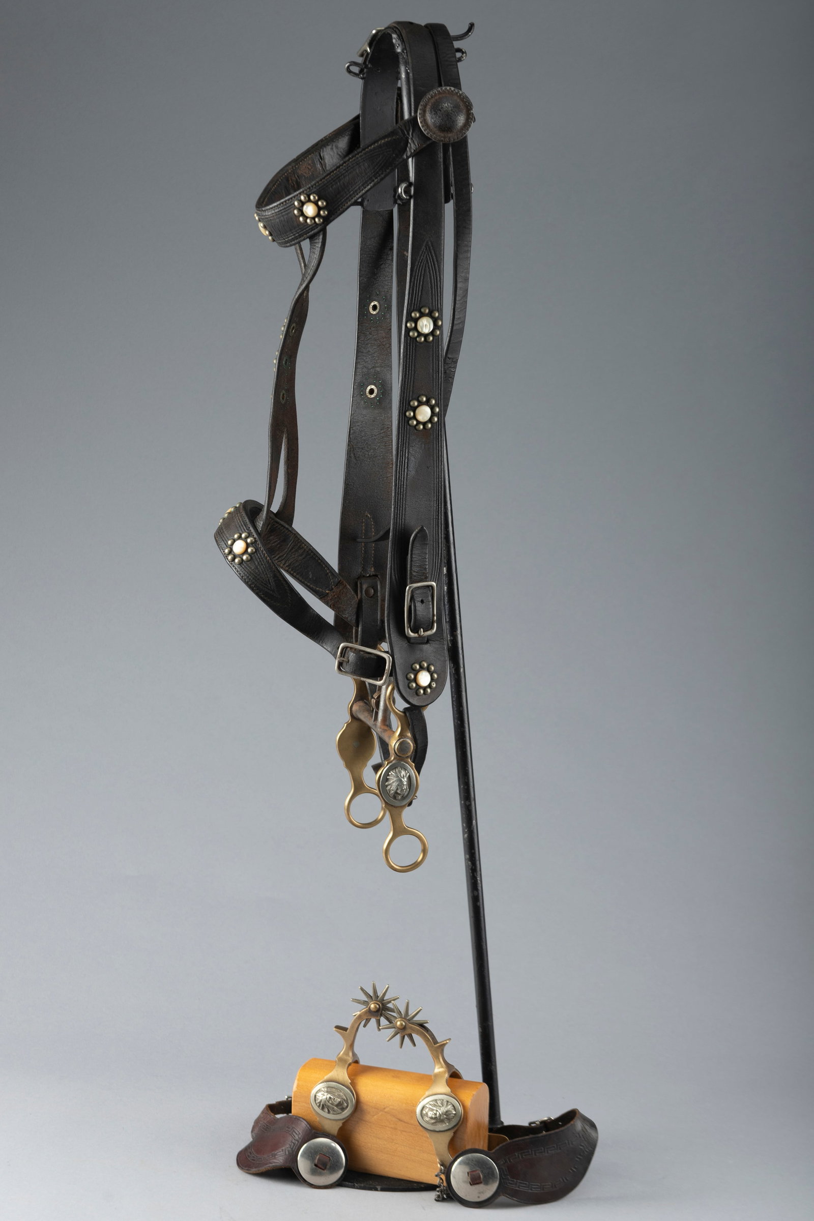 Unique vintage Bridle, Bit and matching Spurs. Bridle is mounted with silver spots and mother of: Unique vintage Bridle, Bit and matching Spurs. Bridle is mounted with silver spots and mother of pearl buttons and mounted with a Hercules bronze Indian Head Bit and matching Spurs. Spurs have two-pie
