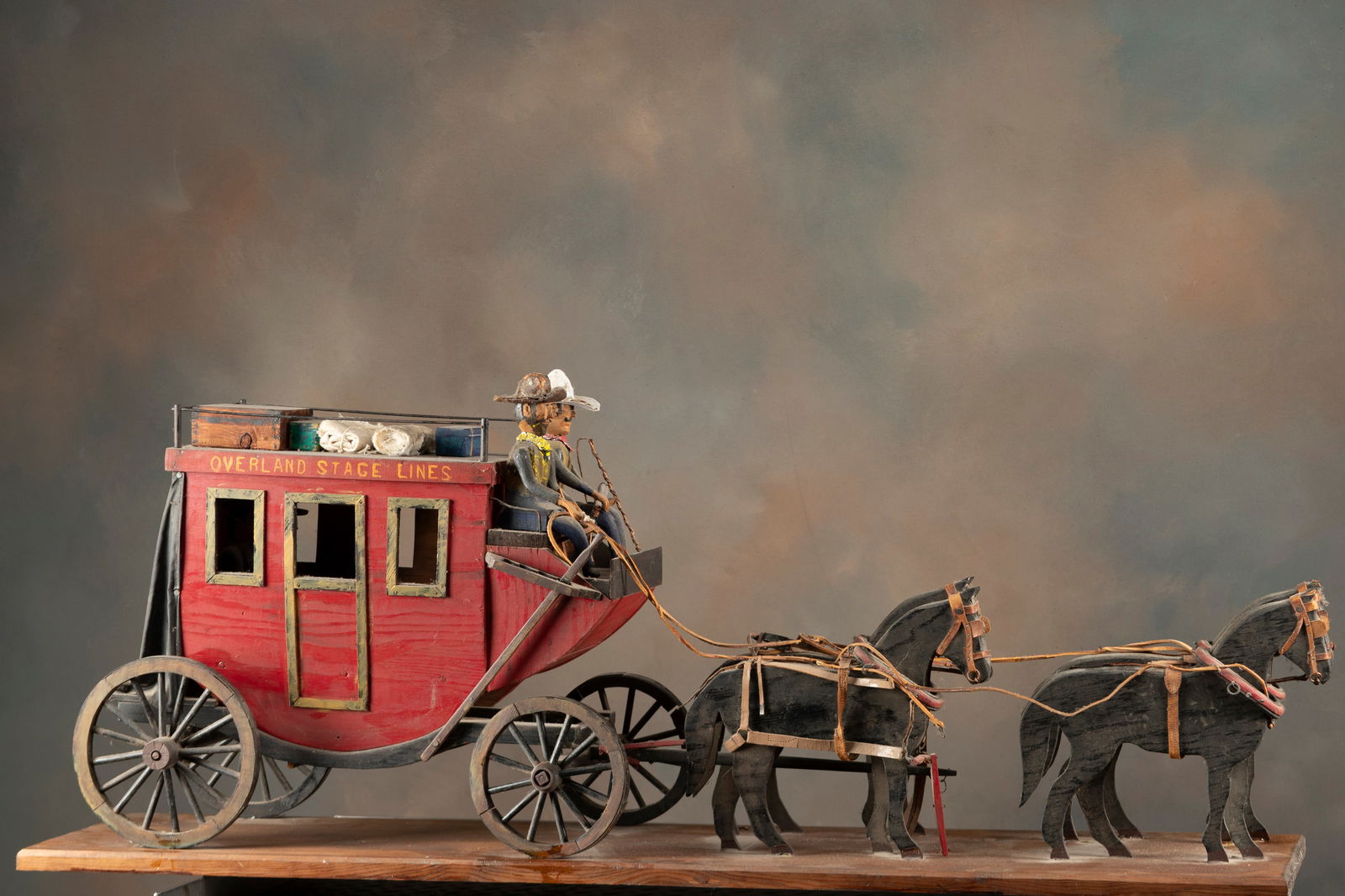 Unique early Folk Art handmade Stage Coach marked "Overland Stage Lines". Rig is 44" L x 9" W x 18": Unique early Folk Art handmade Stage Coach marked "Overland Stage Lines". Rig is 44" L x 9" W x 18" T with four horses and two riders. Coach includes handmade luggage, and sits on a wooden base that m