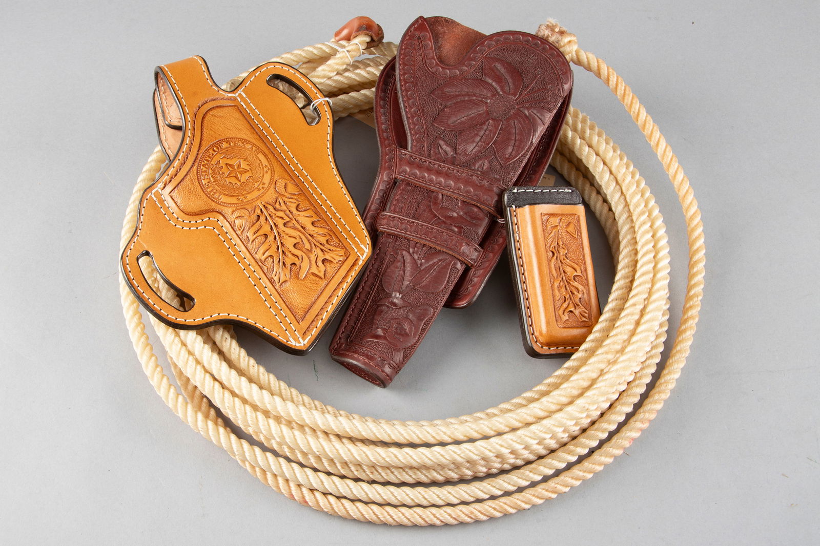 This lot consists of four Items to include: (1) A 24 ft. Lariat Rope. (2) A tooled double loop: This lot consists of four Items to include: (1) A 24 ft. Lariat Rope. (2) A tooled double loop Holster for 7 1/2" single action marked "Wild Bill Original". (3) Custom made tooled Holster for a Model
