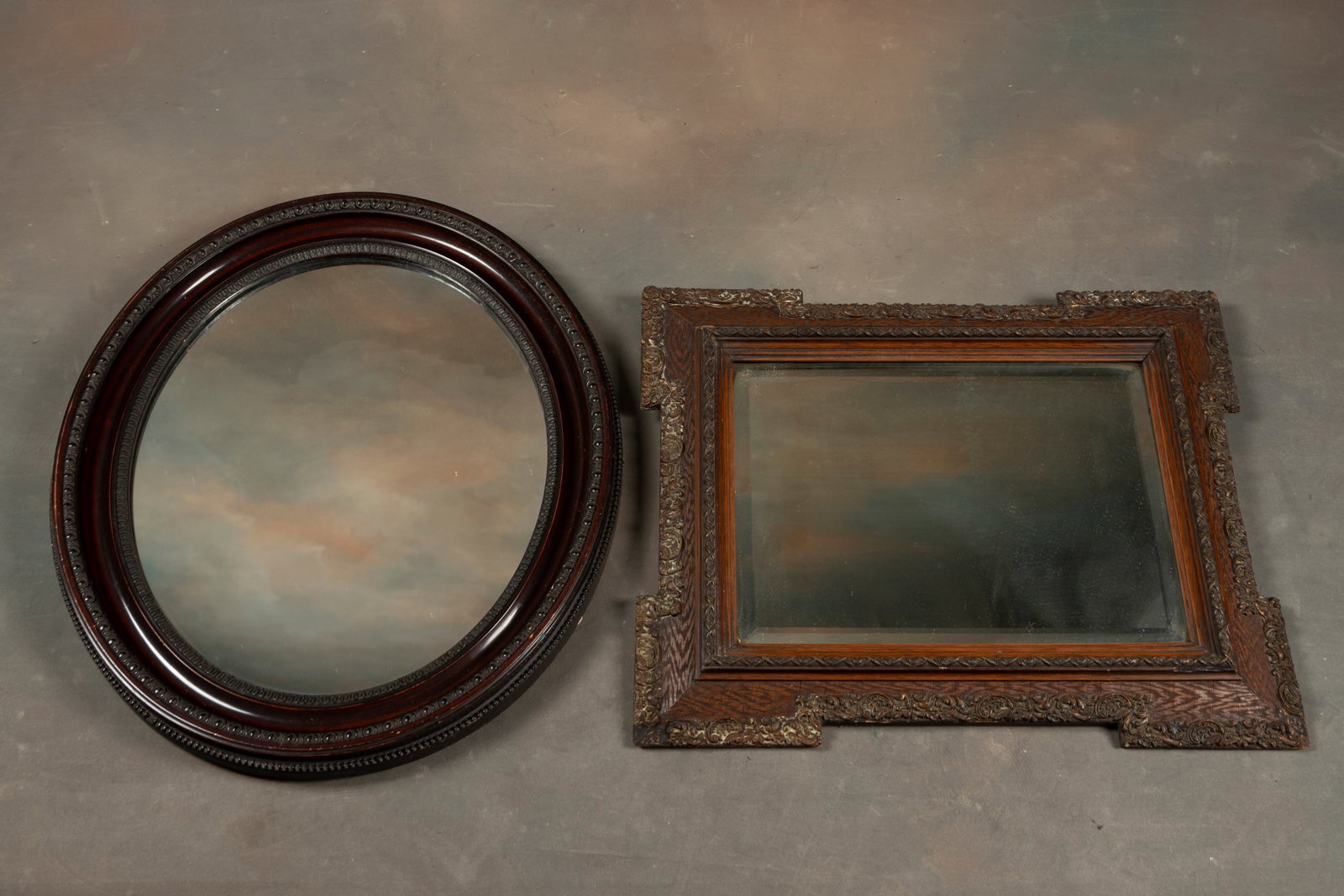 This lot consists of two antique Hanging Mirrors. One is a fancy oval Mirror that measures 25" W x: This lot consists of two antique Hanging Mirrors. One is a fancy oval Mirror that measures 25" W x 21" T. The other is an unusual shaped Beveled Mirror that measures 23" L x 18 1/2" T. WILL BE SOLD AS