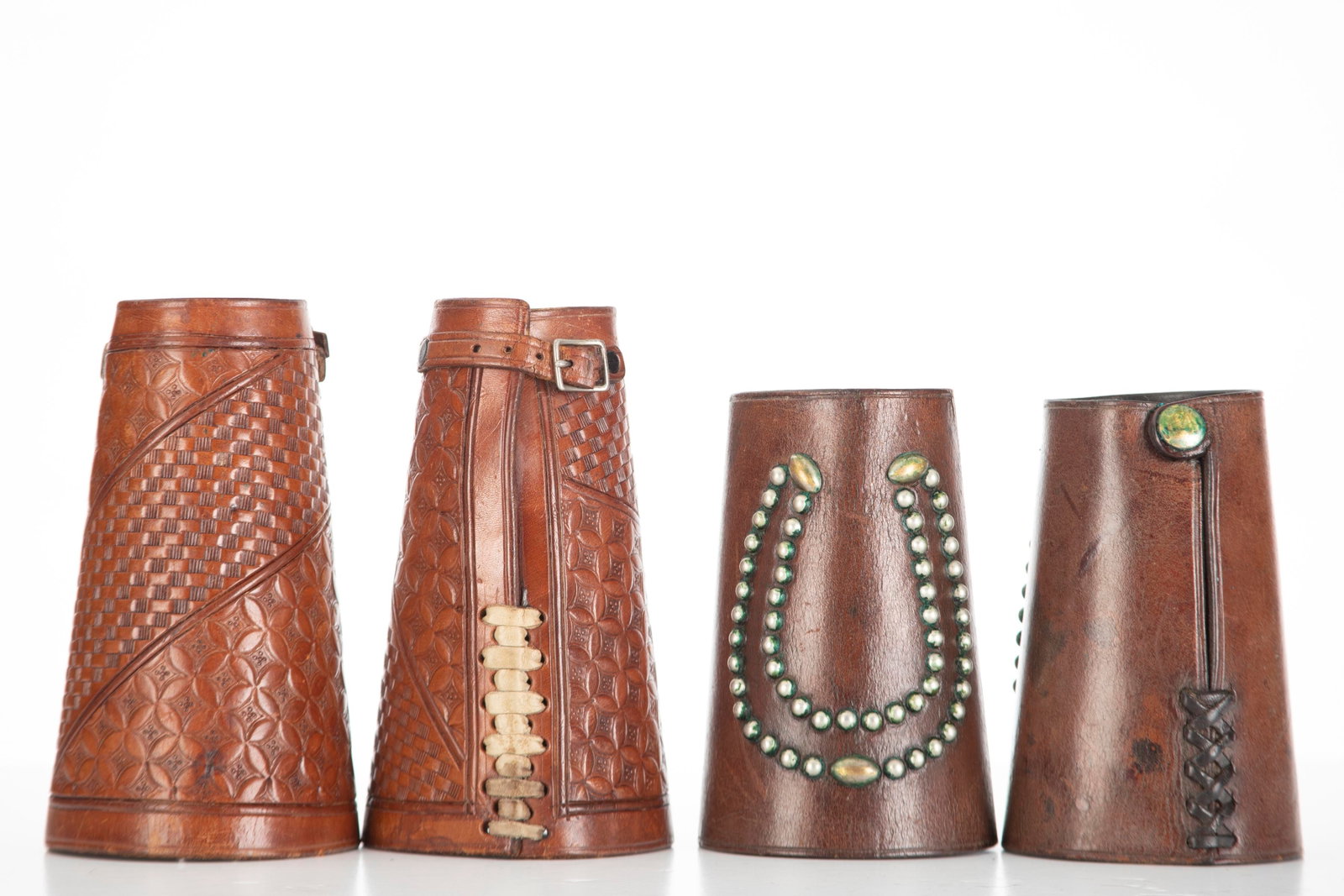 Two Pairs of vintage Leather Roping Cuffs, one pair is 7 1/4" T with basket weave design. The other: Two Pairs of vintage Leather Roping Cuffs, one pair is 7 1/4" T with basket weave design. The other pair is 6" T with silver spotted horse shoes. Leather is supple.