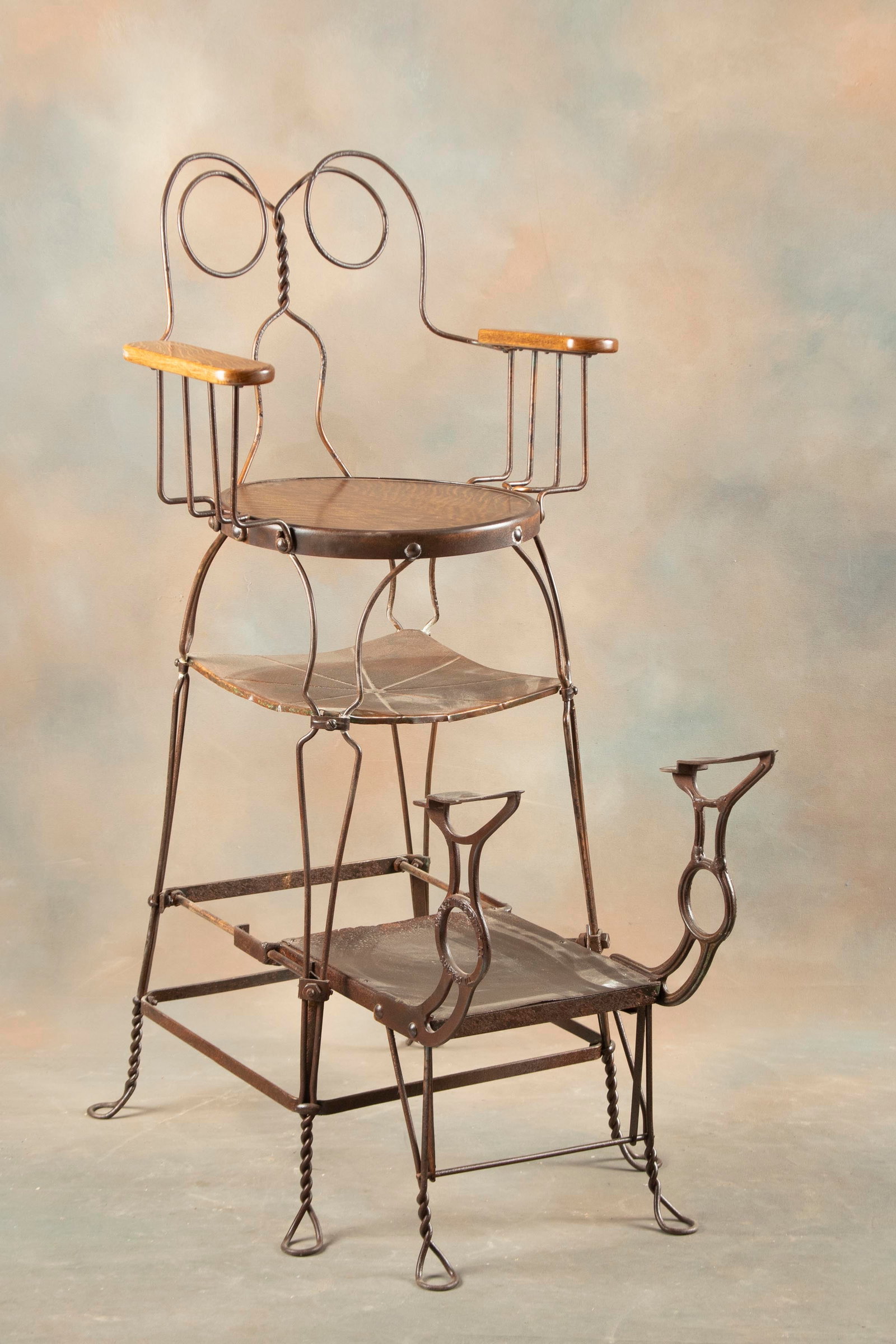 Antique Shoe Shine Stand with quarter sawn oak seat and arms, measures 51" T x 24" W x 24" D, with: Antique Shoe Shine Stand with quarter sawn oak seat and arms, measures 51" T x 24" W x 24" D, with pull out cast iron adjustable shoe rest. This chair was made in two models, this being the most desir