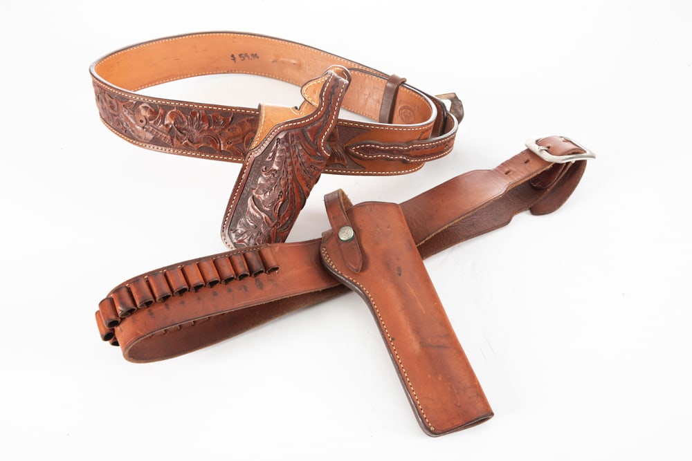 Collection of four Holster & Cartridge Belts for Pistols and Revolvers some tooled, one plain. One: Collection of four Holster & Cartridge Belts for Pistols and Revolvers some tooled, one plain. One Belt and Holster Rig is marked in an oval "Compito's Leather Work / Pedro V. Yegguirre / 38"; Another