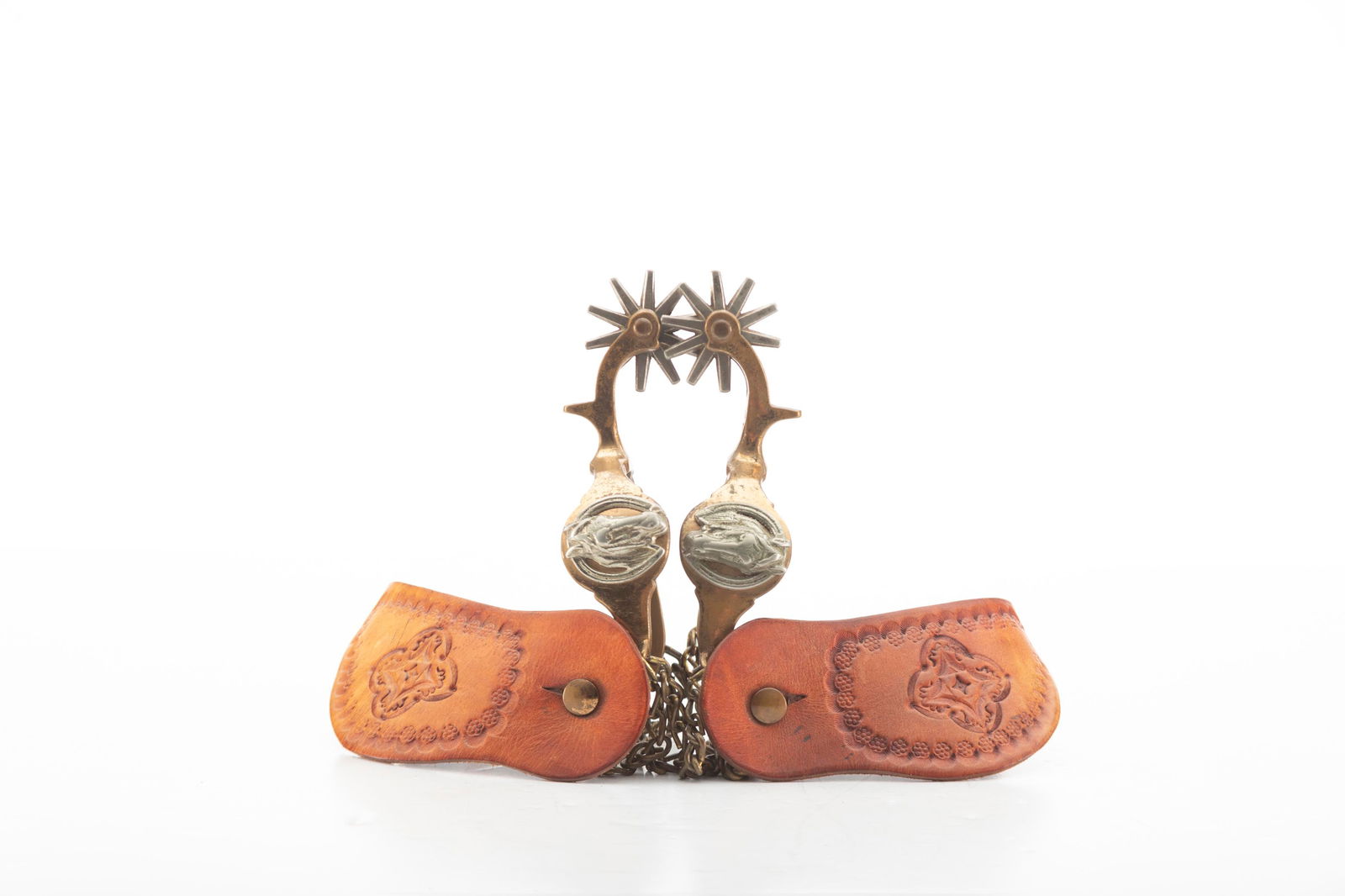 Pair of "Star" marked single mounted Buermann Hercules Bronze Spurs with raised horse head and horse: Pair of "Star" marked single mounted Buermann Hercules Bronze Spurs with raised horse head and horse shoe on heel bands, complete with original heel chains and two-piece leather straps. THE BUDDY KING