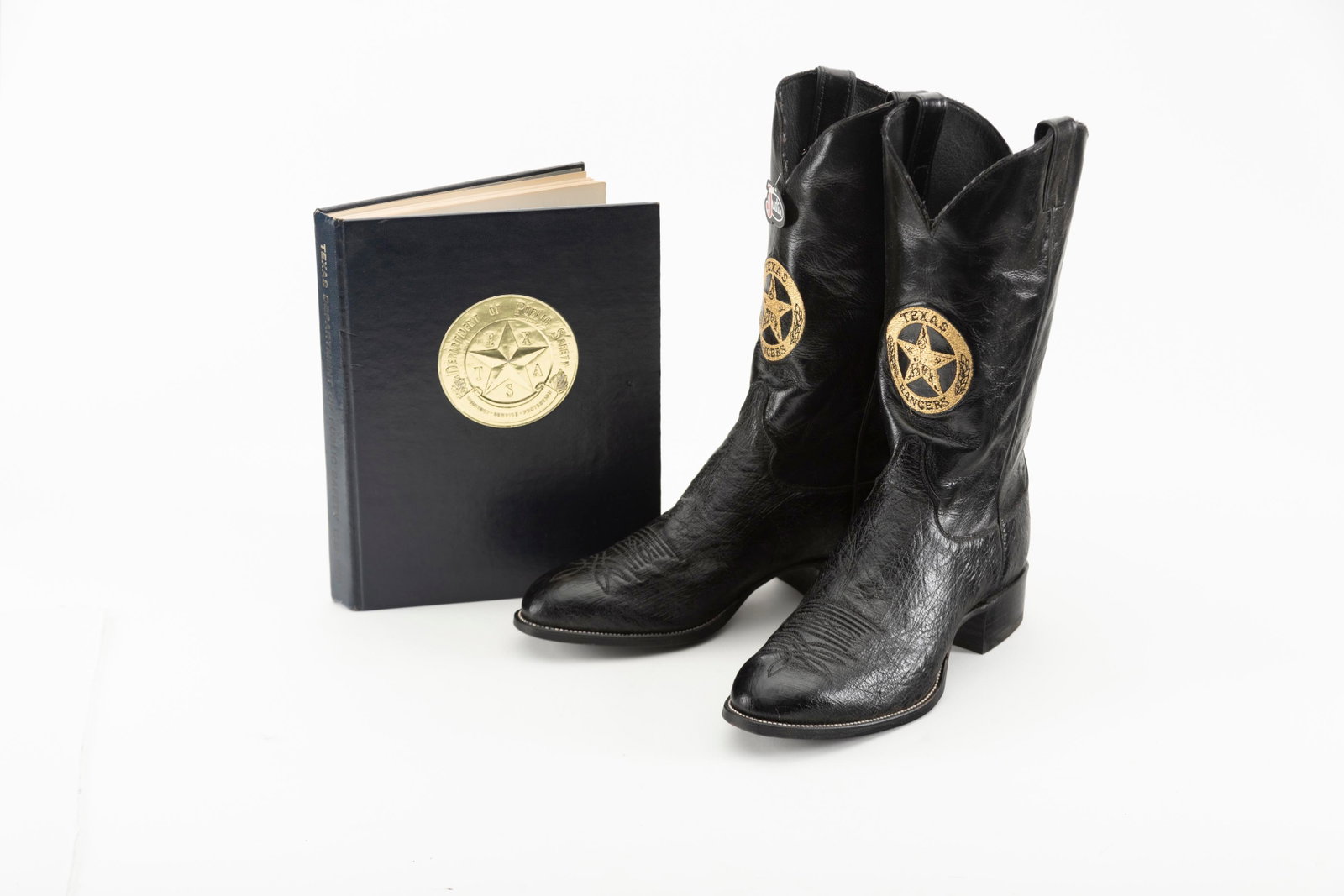 A pair of as new Justin Western Dress Boots size 10 1/2 EE, tops have gold embroidered circle / star: A pair of as new Justin Western Dress Boots size 10 1/2 EE, tops have gold embroidered circle / star Texas Ranger Badge. Boots will be accompanied by a Book titled "Texas Department Of Public Safety 1