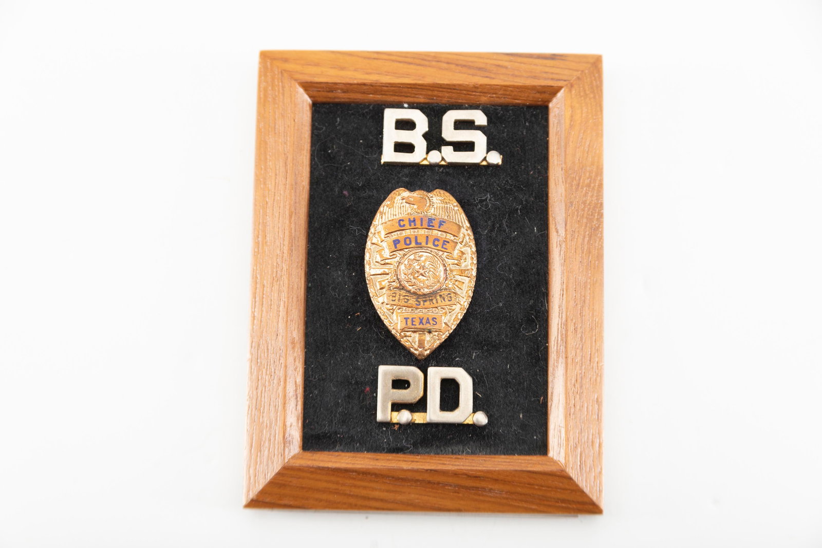 Gold Shield Badge with raised porcelain letters marked "Chief of Police / Big Spring, Texas" 1 1/2": Gold Shield Badge with raised porcelain letters marked "Chief of Police / Big Spring, Texas" 1 1/2" T x 1" W, showing some wear. THE LATE PAUL CHAPMAN ESTATE.
