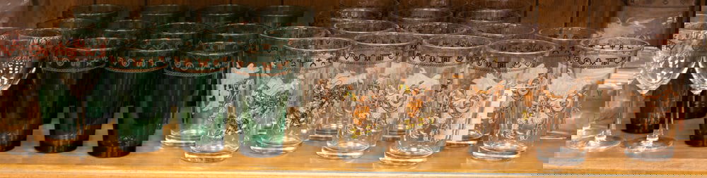 Glassware marked "Westward Ho / Rodeo Pattern / True West / Goldthwaite, Texas 1991. Pieces to: Glassware marked "Westward Ho / Rodeo Pattern / True West / Goldthwaite, Texas 1991. Pieces to include: 5 Clear Wine Glasses (6 1/2" T); 12 Green Glasses (5 7/8" T); 16 Clear Glasses (6 1/4"T); Set of