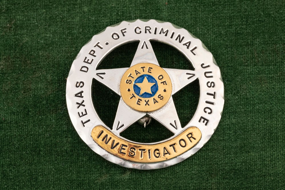 Silver tone Circle Badge with 5-point cut-out Star, measures 2 ¼??D, marked “TEXAS DEPT OF: Silver tone Circle Badge with 5-point cut-out Star, measures 2 ¼”D, marked “TEXAS DEPT OF CRIMINAL JUSTICE”, gold tone lower banner marked “INVESTIGATOR”, gold tone center