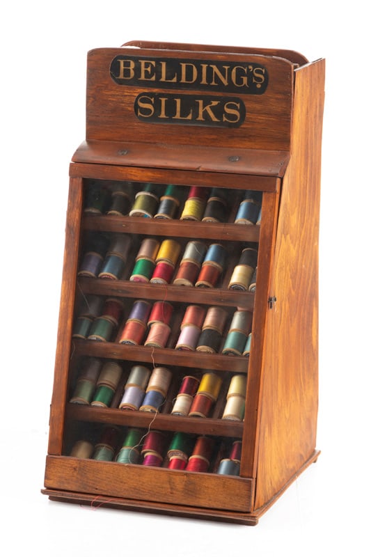 Unusual country store wooden and glass front Thread Case marked "BELDING'S SILK", contains over 70: Unusual country store wooden and glass front Thread Case marked "BELDING'S SILK", contains over 70 spools of silk thread. Case measures 21" T x 11 1/4" at base x 10 1/2" W. THE BUDDY KING COLLECTION.