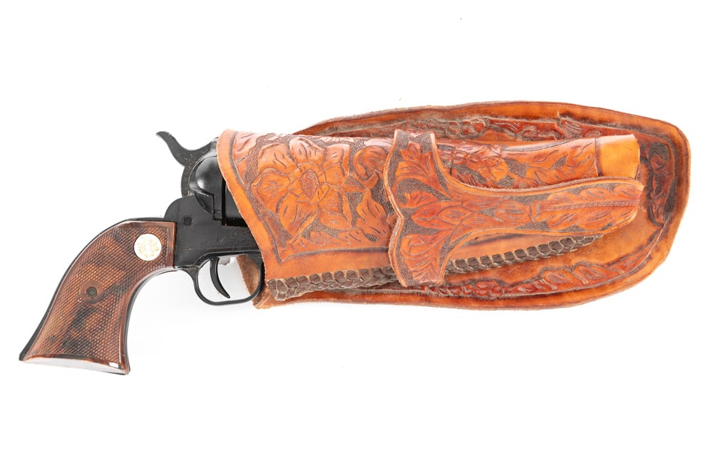 Rich brown, highly tooled Holster with a jockey strap style loop for a single or double action: Rich brown, highly tooled Holster with a jockey strap style loop for a single or double action revolver, very good condition. Holster is accompanied by a Hollywood style Prop Revolver. WILL BE SOLD AS