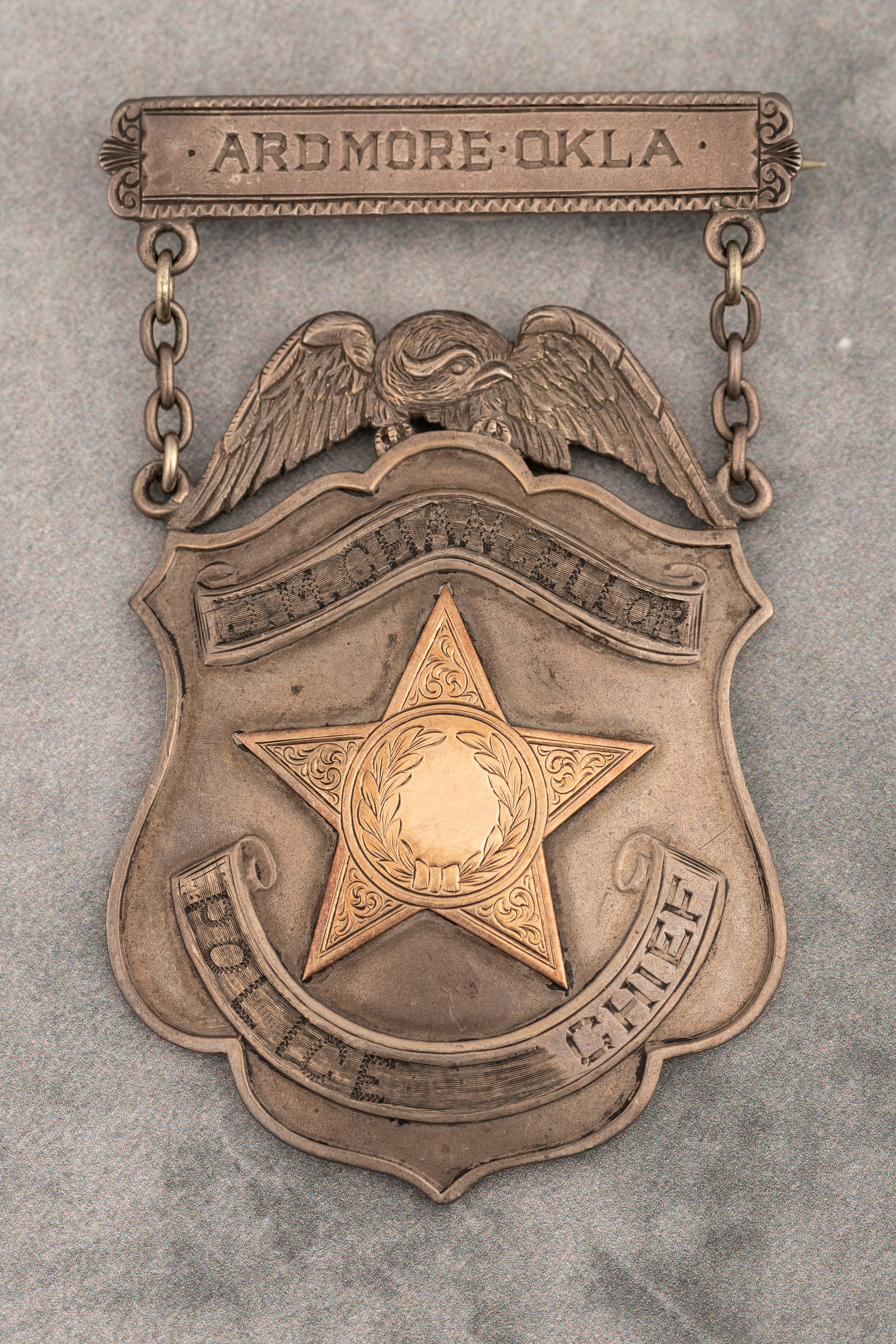 Large vintage, heavy Suspension Badge, shield with eagle crest, marked "Ardmore Okla./ J.N.: Large vintage, heavy Suspension Badge, shield with eagle crest, marked "Ardmore Okla./ J.N. Chancellor/Police Chief". Badge has possibly gold filled, raised 5-point star center. The suspended header h