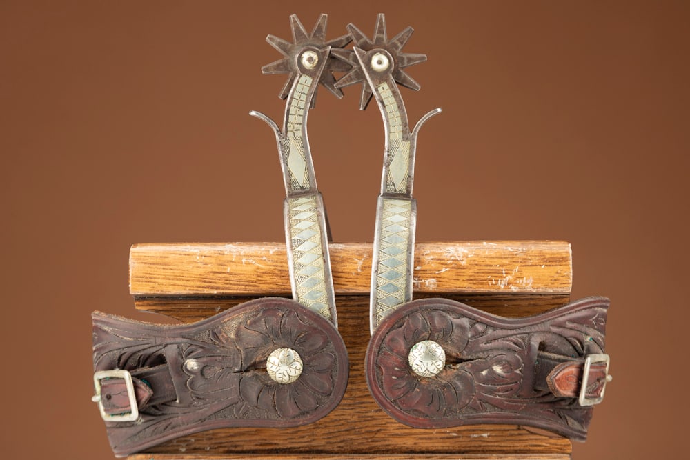 Fine pair of Canon City prison made, double mounted Spurs done in the diamond pattern with chap: Fine pair of Canon City prison made, double mounted Spurs done in the diamond pattern with chap guards. Excellent condition, mounted with vintage two-piece floral tooled straps. HUTCHESON COLLECTION