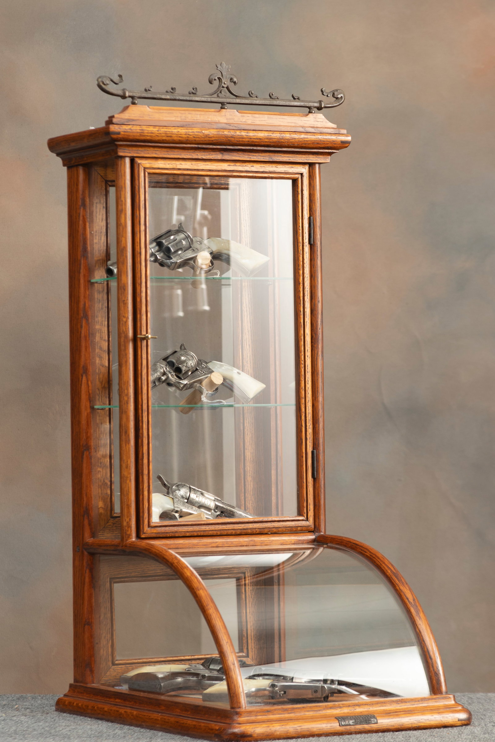 "J.W. Winchester" marked, oak case, curved glass counter top model Showcase with metal gallery top: "J.W. Winchester" marked, oak case, curved glass counter top model Showcase with metal gallery top and double door entry. Showcase measures 36" T x 15" W x 20" D at base. Excellent finish and conditio