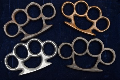This lot will consist of 4 vintage "Knucks" in wooden and glass Showcase to include: (1) One brass