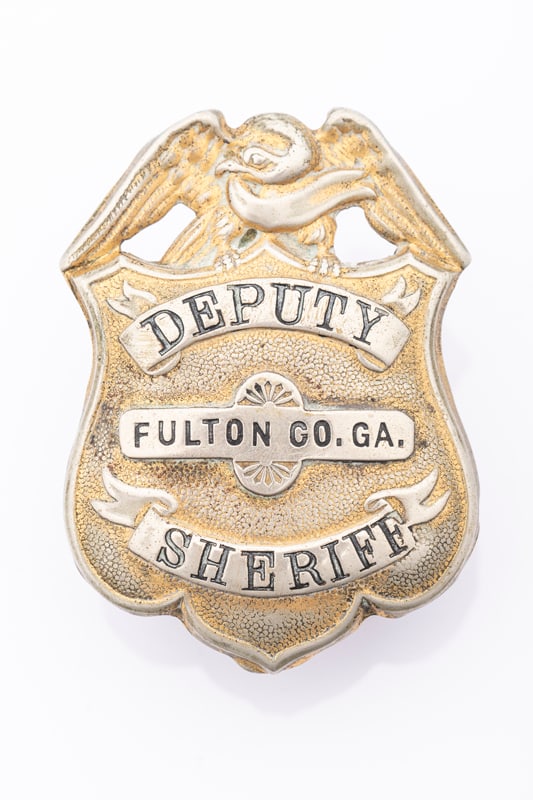 Large vintage Shield Badge with eagle crest marked "Deputy / Fulton / Co. Ga. / Sheriff", showing: Large vintage Shield Badge with eagle crest marked "Deputy / Fulton / Co. Ga. / Sheriff", showing lots of wear from use with some of the gold tone is still present. Nice heavy pin with tongue catch , 