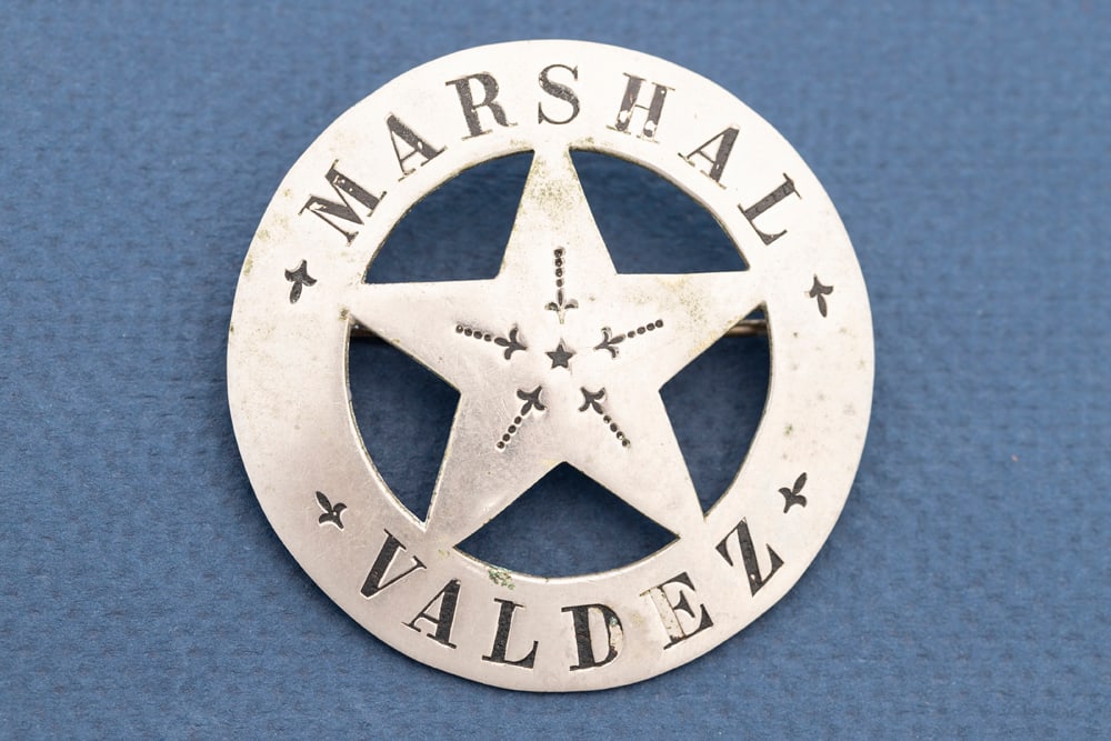 Vintage Circle Star Badge with 5-point cut out star marked "Marshal / Valdez", missing some of the: Vintage Circle Star Badge with 5-point cut out star marked "Marshal / Valdez", missing some of the black enamel in lettering. Back is hallmarked "P.C. Stamp WKS / Seattle", has heavy wire pin and catc
