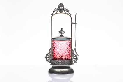 Embossed cranberry and silver Pickle Castor on fancy stand with fork. Stand measures 12" T.